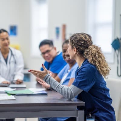 Group of medical professionals talking at a table.
