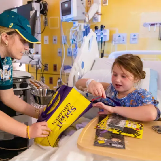 Patient receiving donation of toys and activities while in hospital bed.