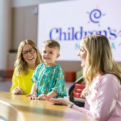 Child Life specialists playing with young patient in the hospital lobby.