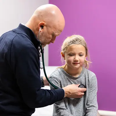 Provider listening to patient's heart.