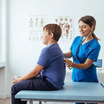 Provider listening to young patient's lungs.