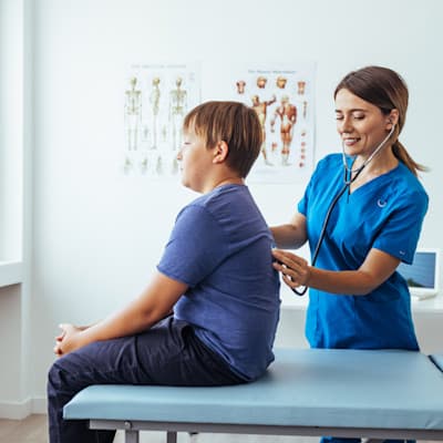 Provider listening to young patient's lungs.