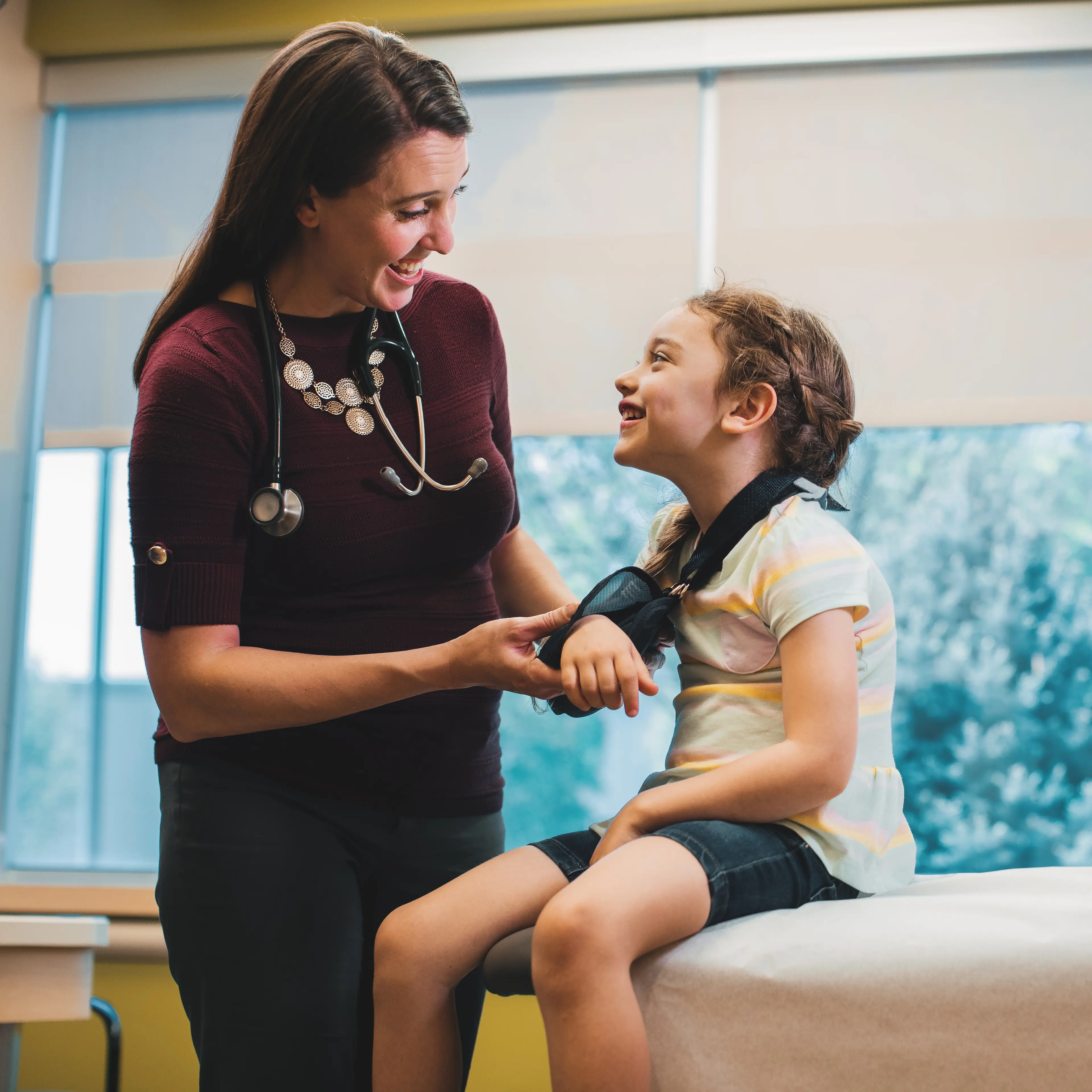 Children's Nebraska provider putting young patient's arm in a sling.