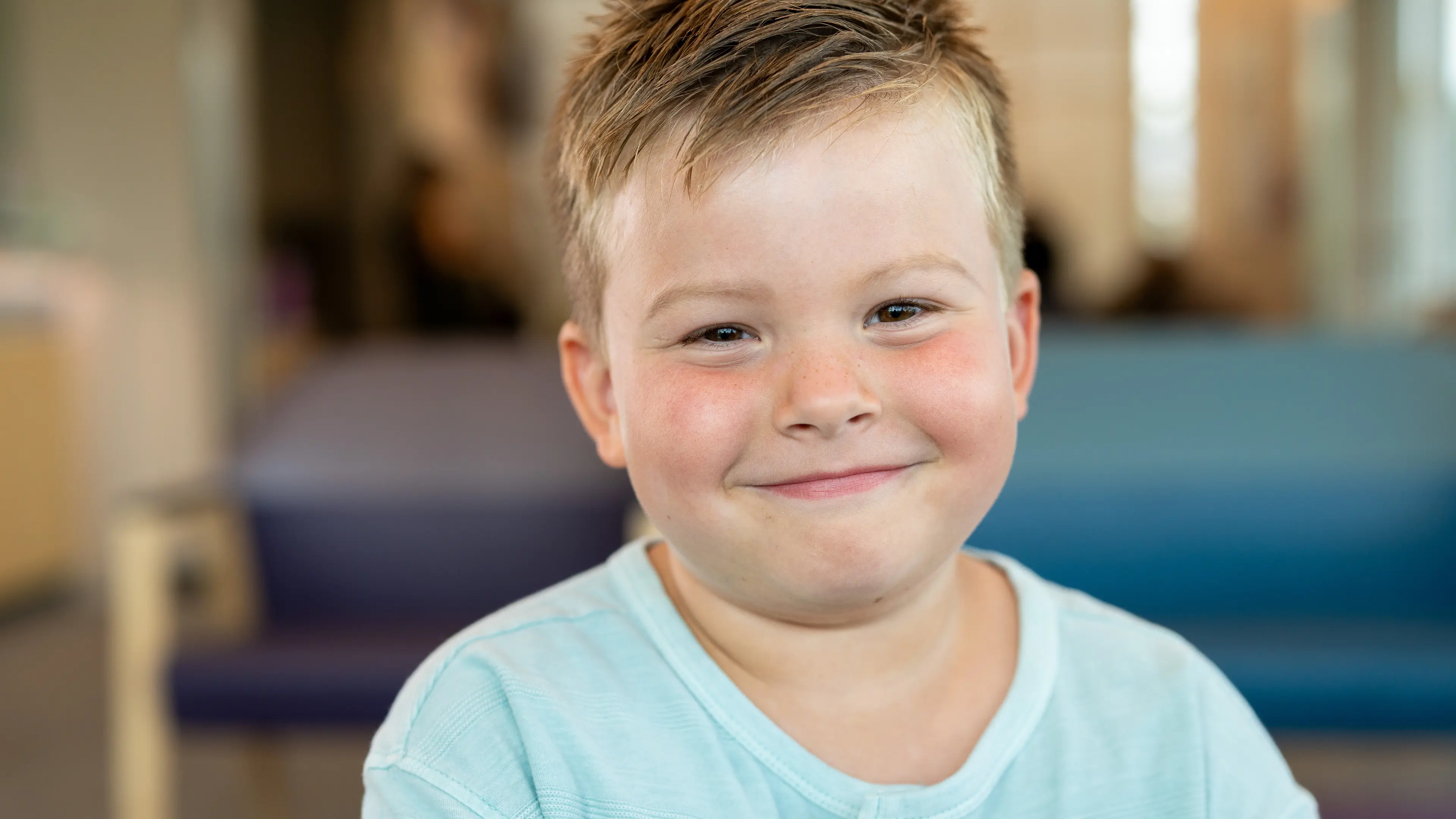 Young boy smiling in the Children's Nebraska hospital lobby.