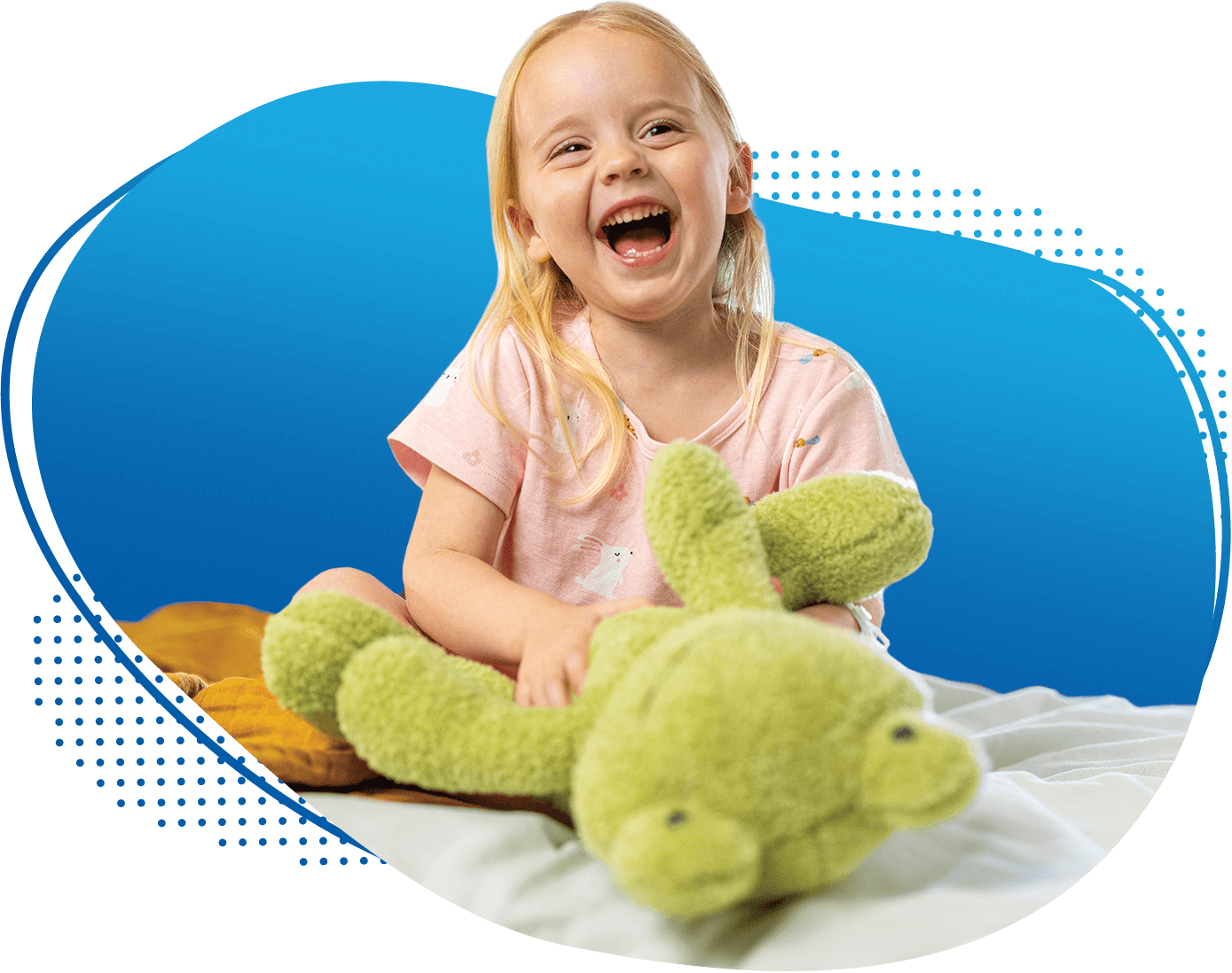 Smiling young female pediatric patient holding a stuffed animal frog toy while sitting on her hospital bed at Children's Nebraska.