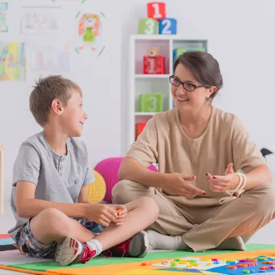 Therapist talking with young boy.