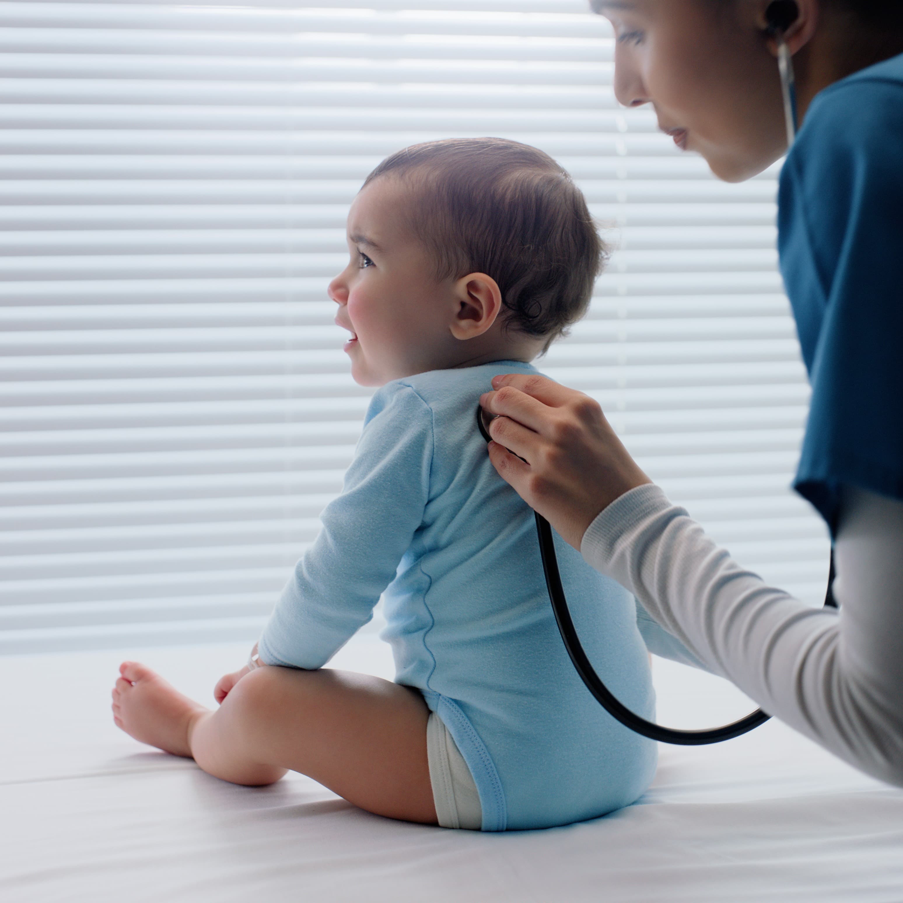 Provider listening to infant's lungs.
