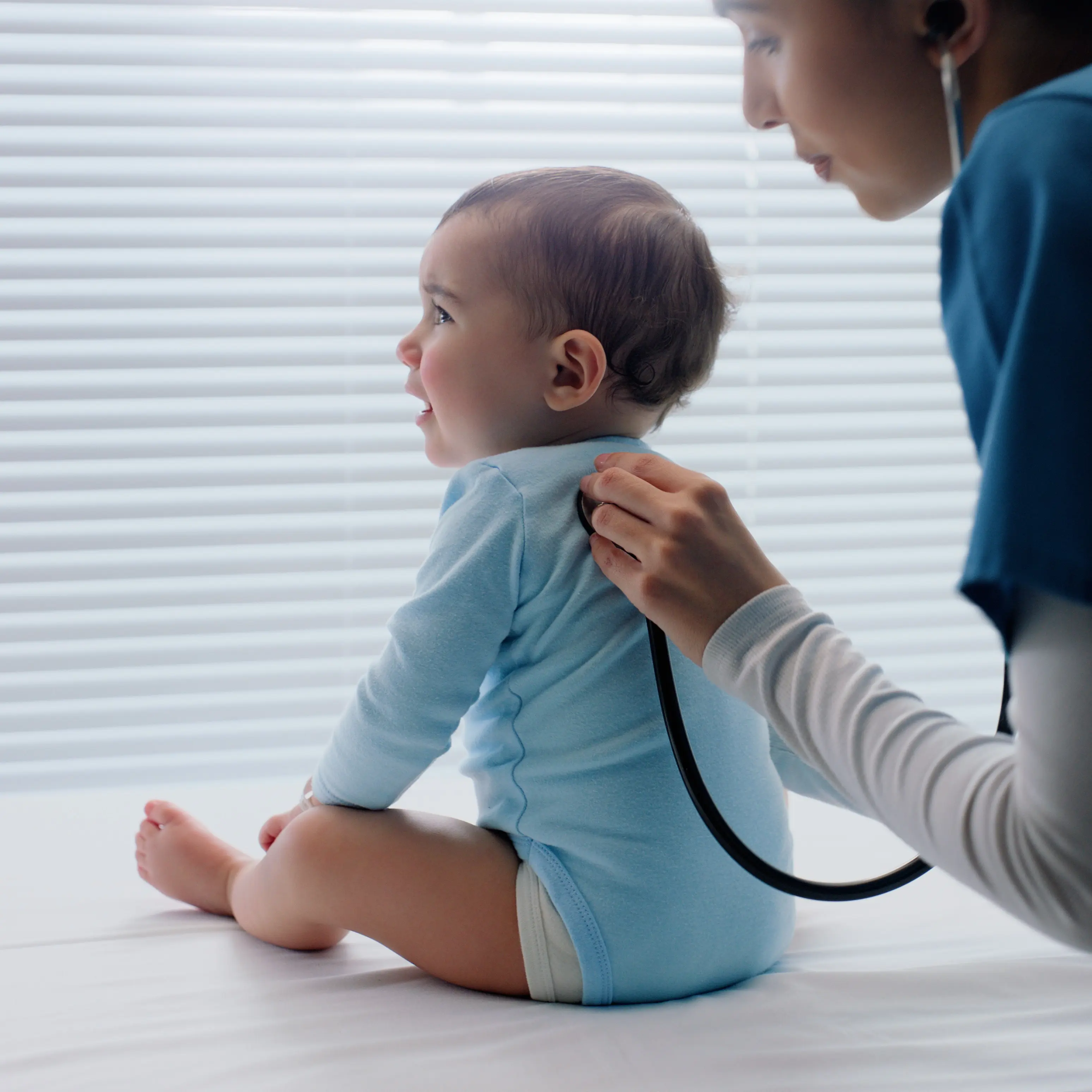 Provider listening to infant's lungs.