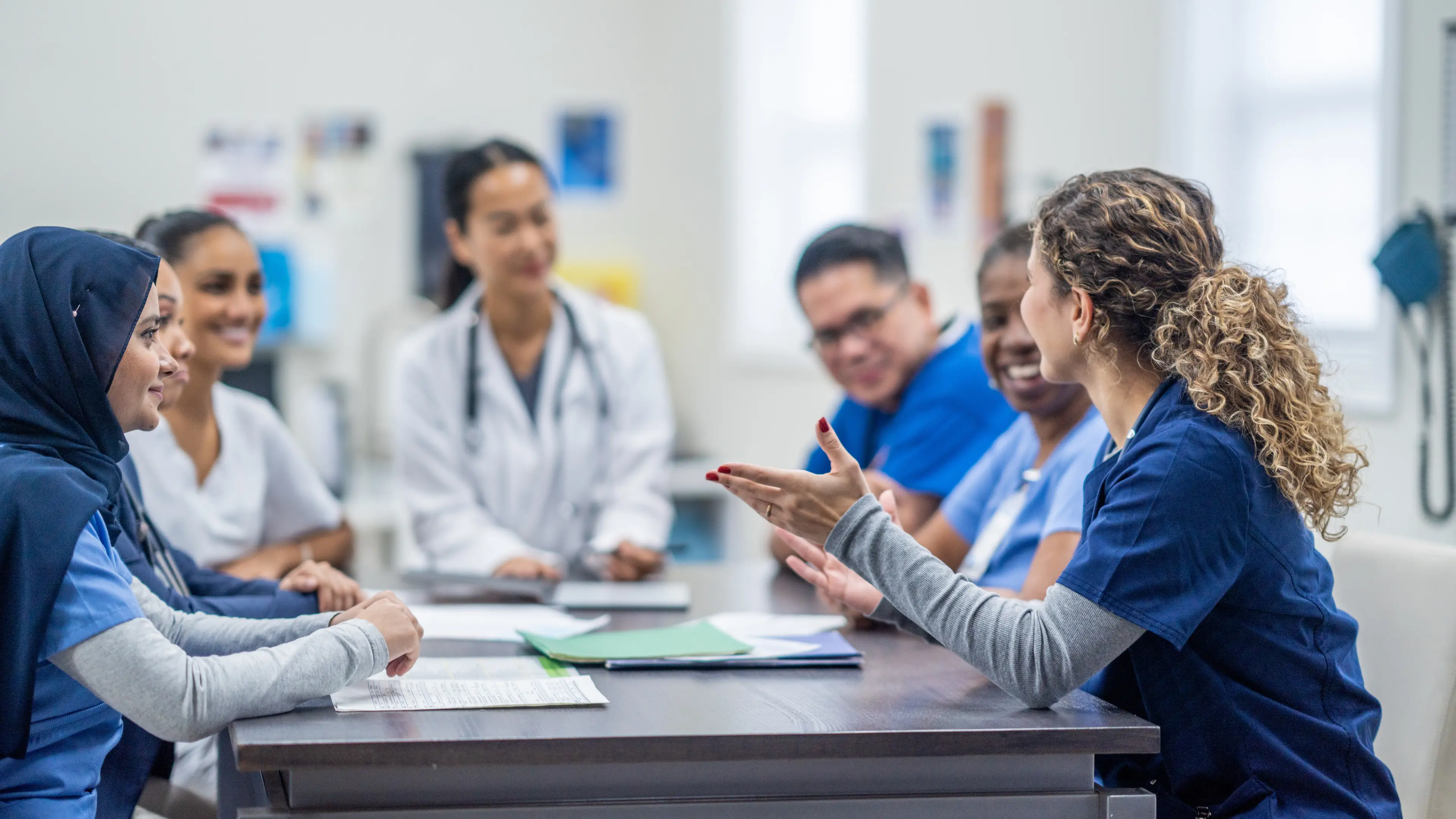 Group of medical professionals talking at a table.