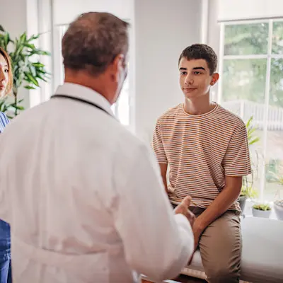 Teen boy talking with doctor.