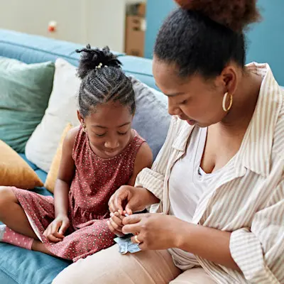 Mother helping daughter with finger poke.