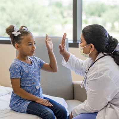 Provider giving high-five to a young patient.