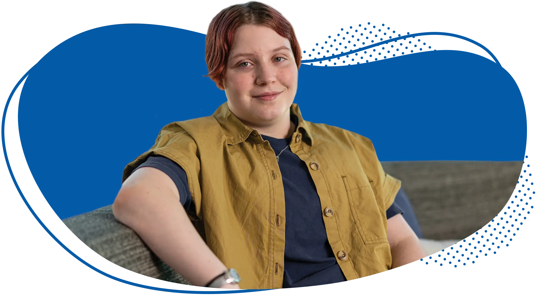 Person with short reddish hair wearing a tan vest over dark shirt against blue background with decorative wave design.