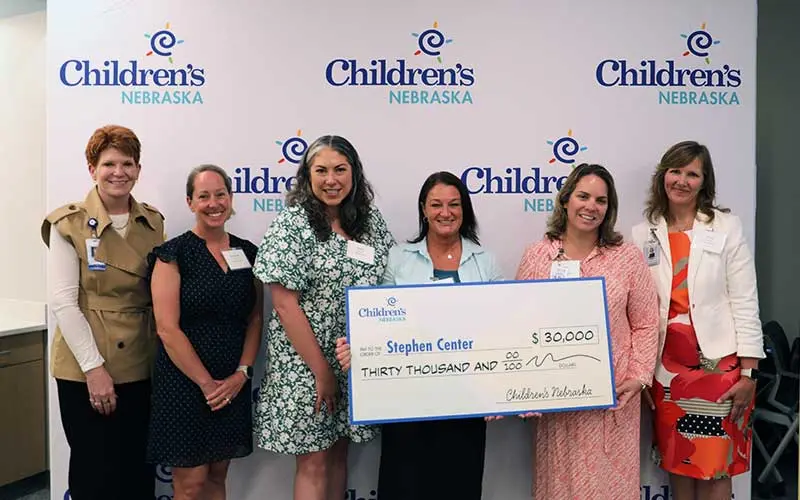 Stephen Center - Foundations for Growth and Children's Nebraska representatives hold a large check for $30,000.