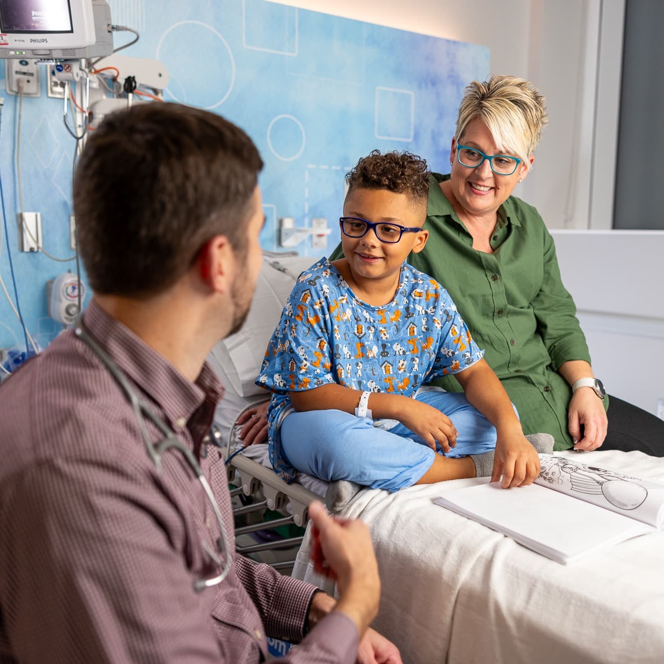 Children's Nebraska provider talking with young patient and mother