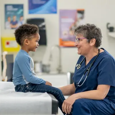 Nurse smiling with young patient.