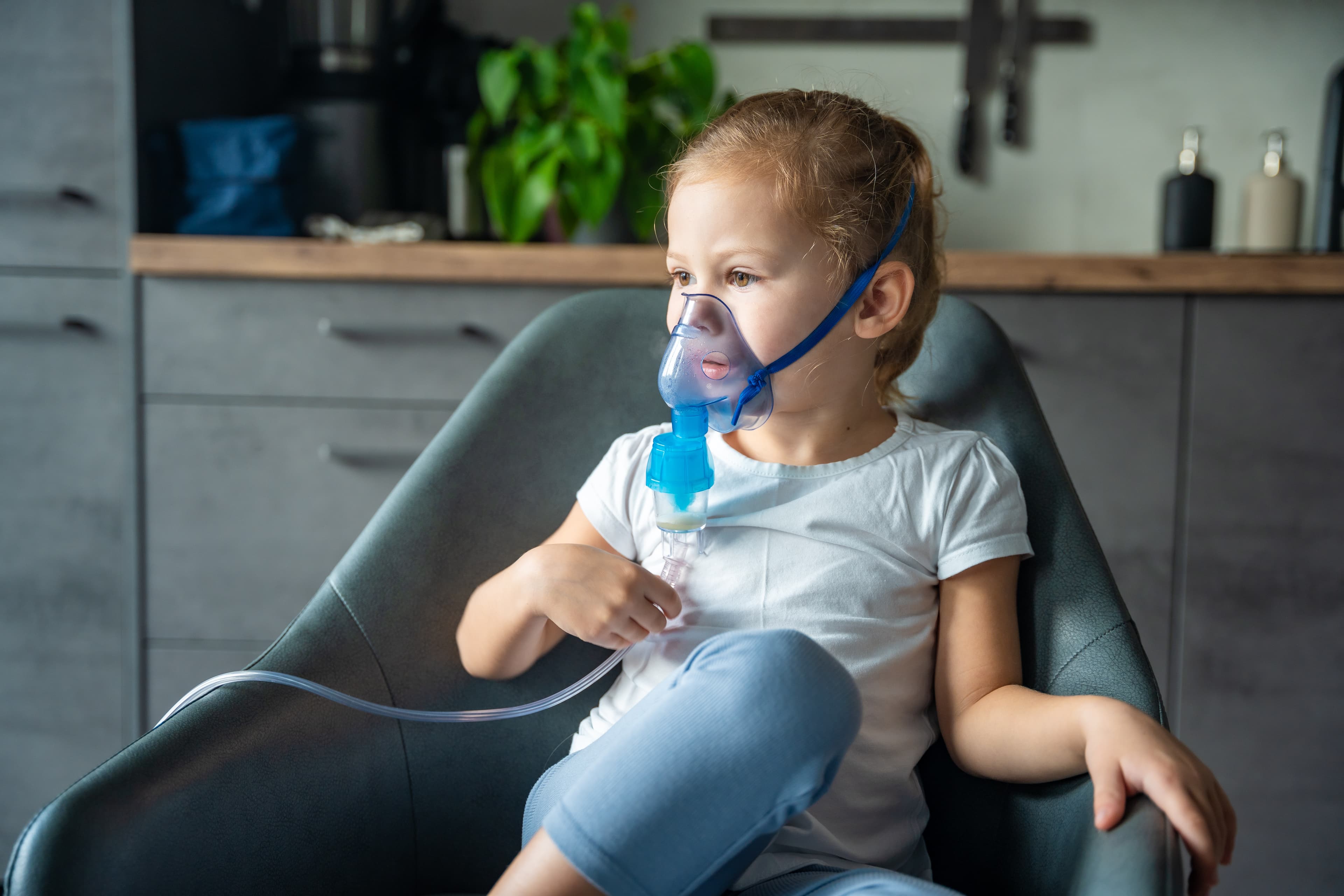 cute little girl are sitting and holding a nebuliz