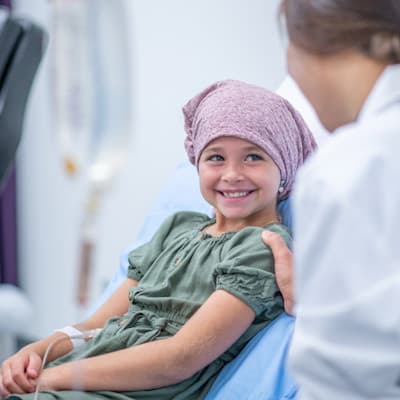 Child with cancer in hospital bed.