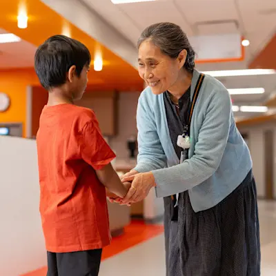 Doctor comforting and smiling with young patient in the Children's Nebraska hospital hallway.
