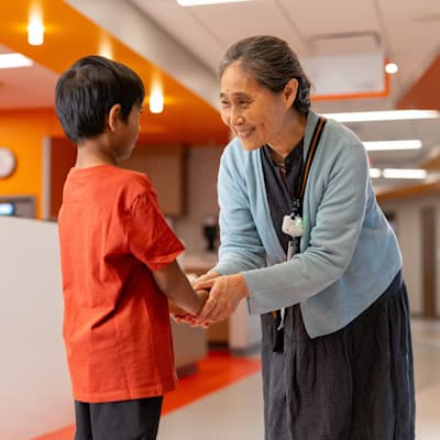 Doctor comforting and smiling with young patient in the Children's Nebraska hospital hallway.