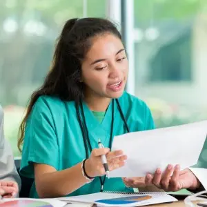 High school student learning from medical provider.