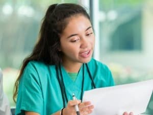 High school student learning from medical provider.