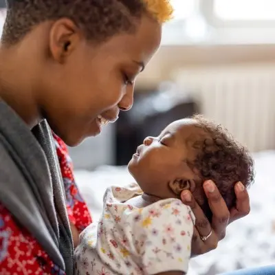 Mother holding infant child.