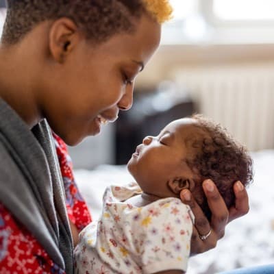 Mother holding infant child.