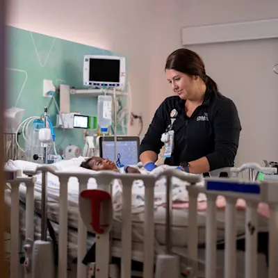 Provider caring for young PICU patient.