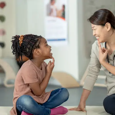 Young girl working with speech therapist.