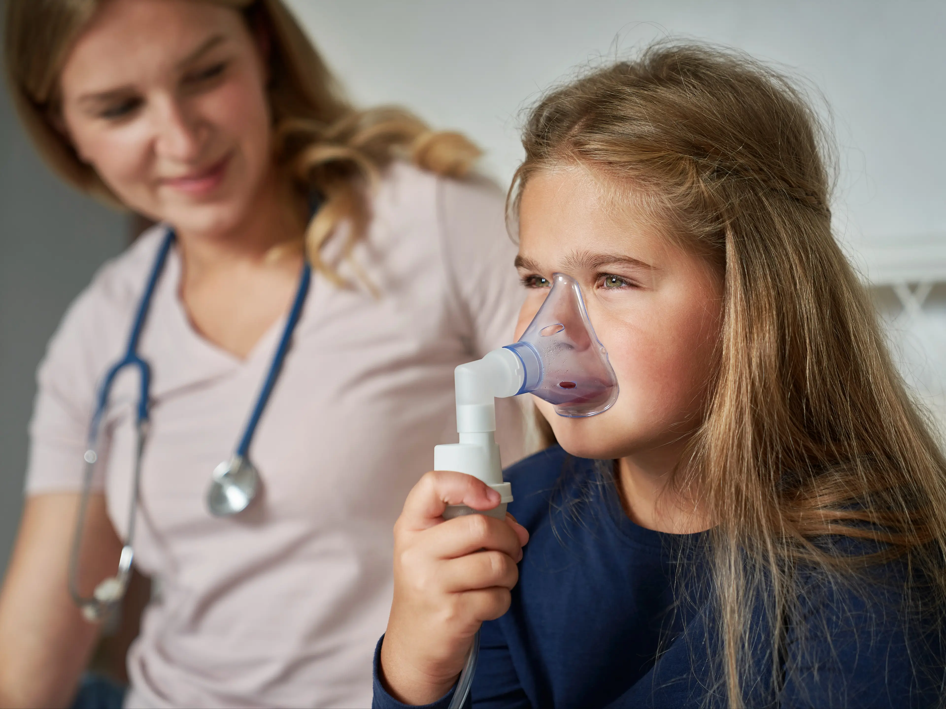 Child using an inhaler with provider.