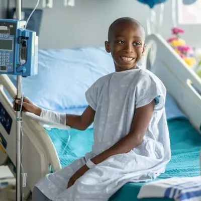 Young patient smiling in hospital bed.