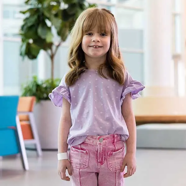 Sloan Rieke wearing a purple shirt and pink pants.