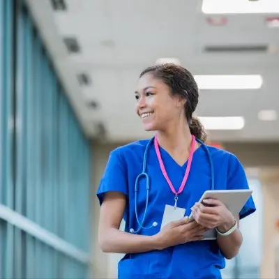 Nursing student walking down hospital hallway.