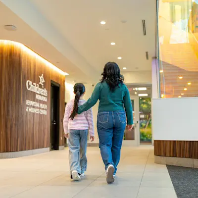 Mother and daughter peacefully walking through the hallway of the new Behavioral Health & Wellness Center at Children's Nebraska.