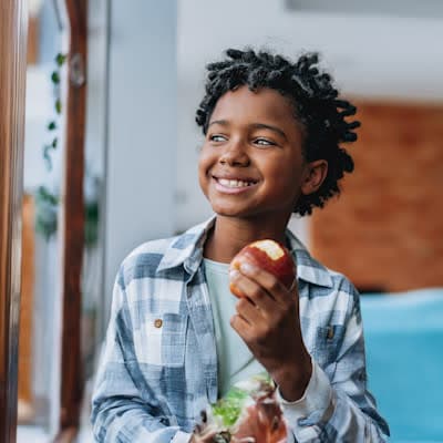 Young boy eating an apple.