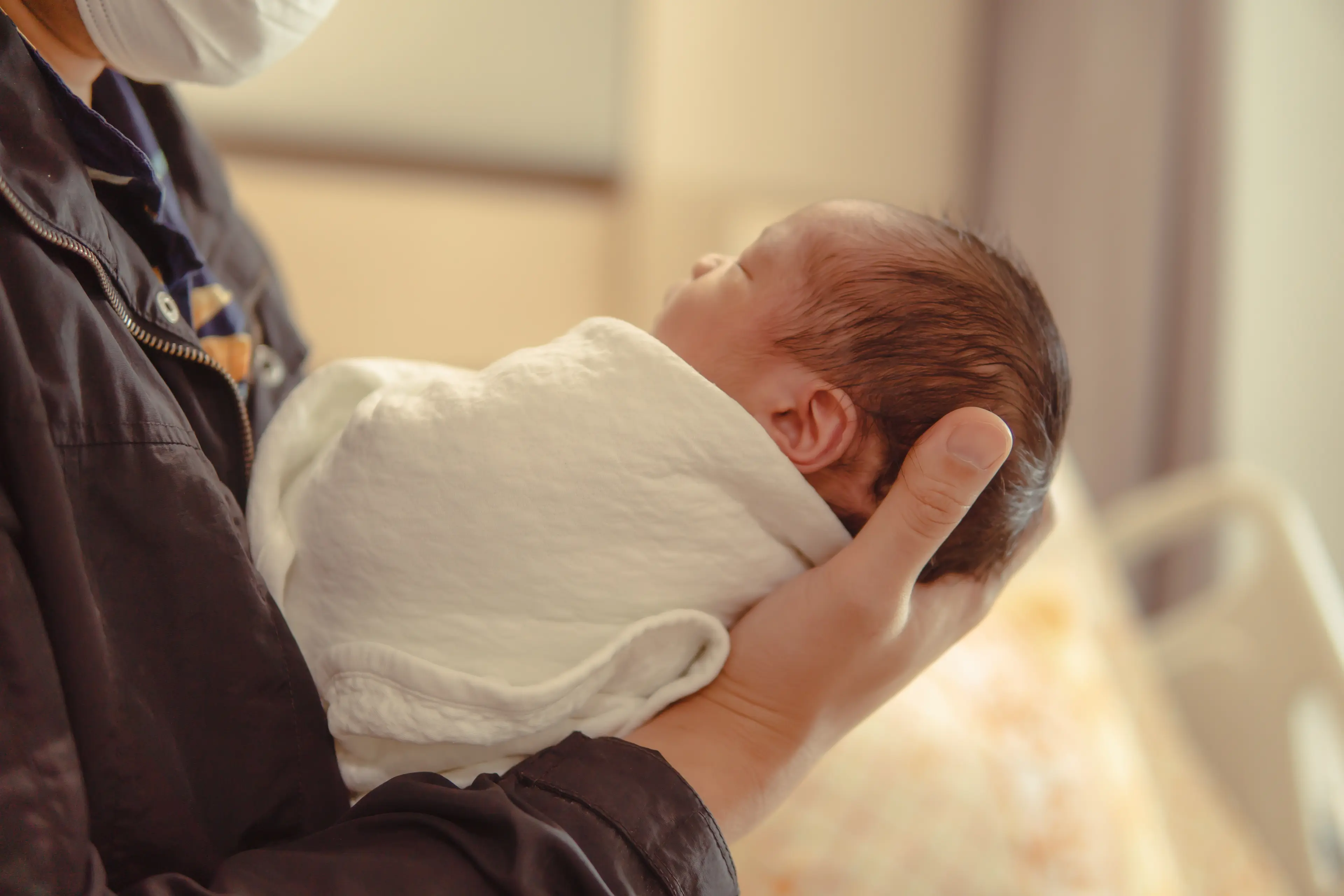 Children’s Outreach and Provider Education. Small baby being held by a medical provider.
