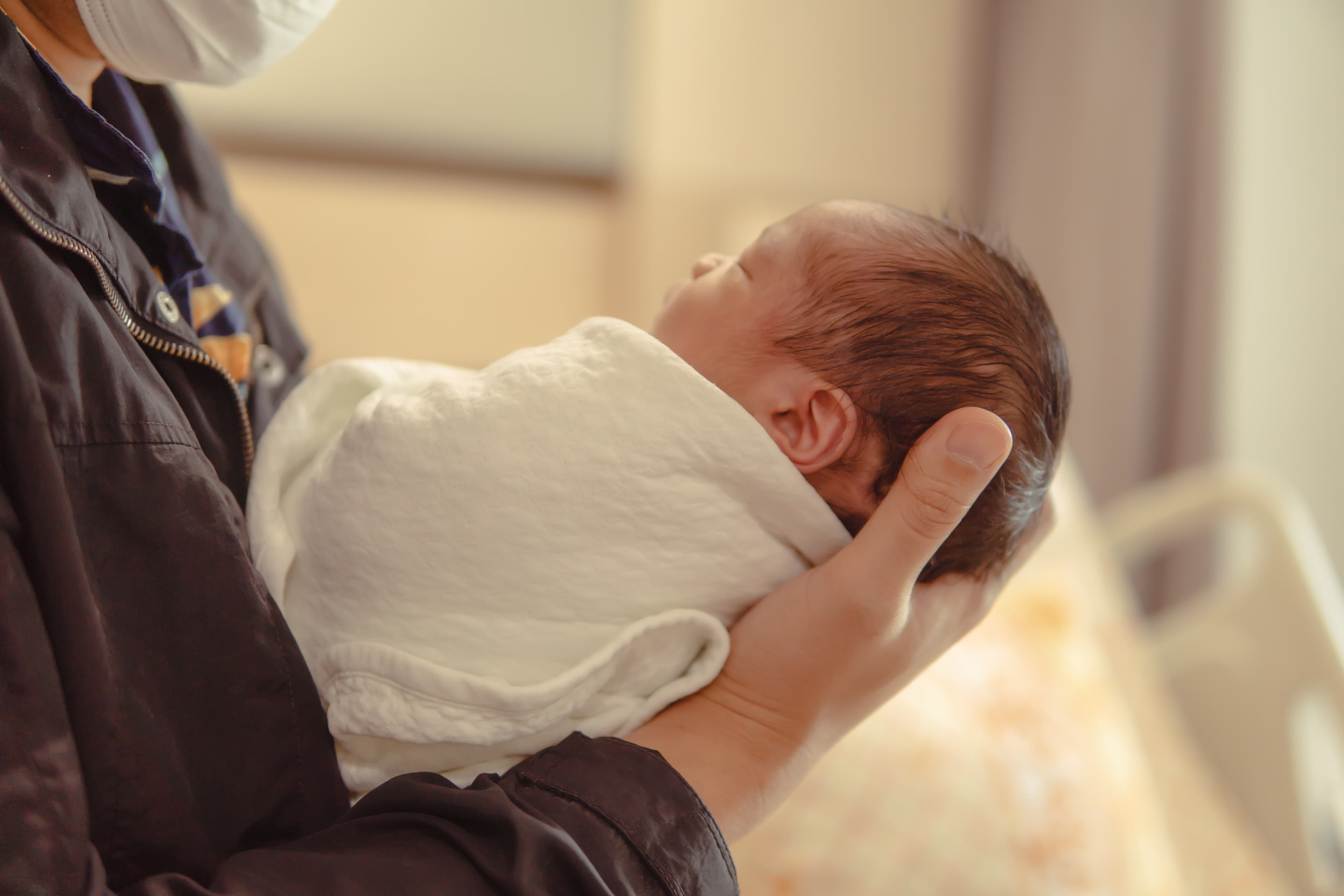 Children’s Outreach and Provider Education. Small baby being held by a medical provider.