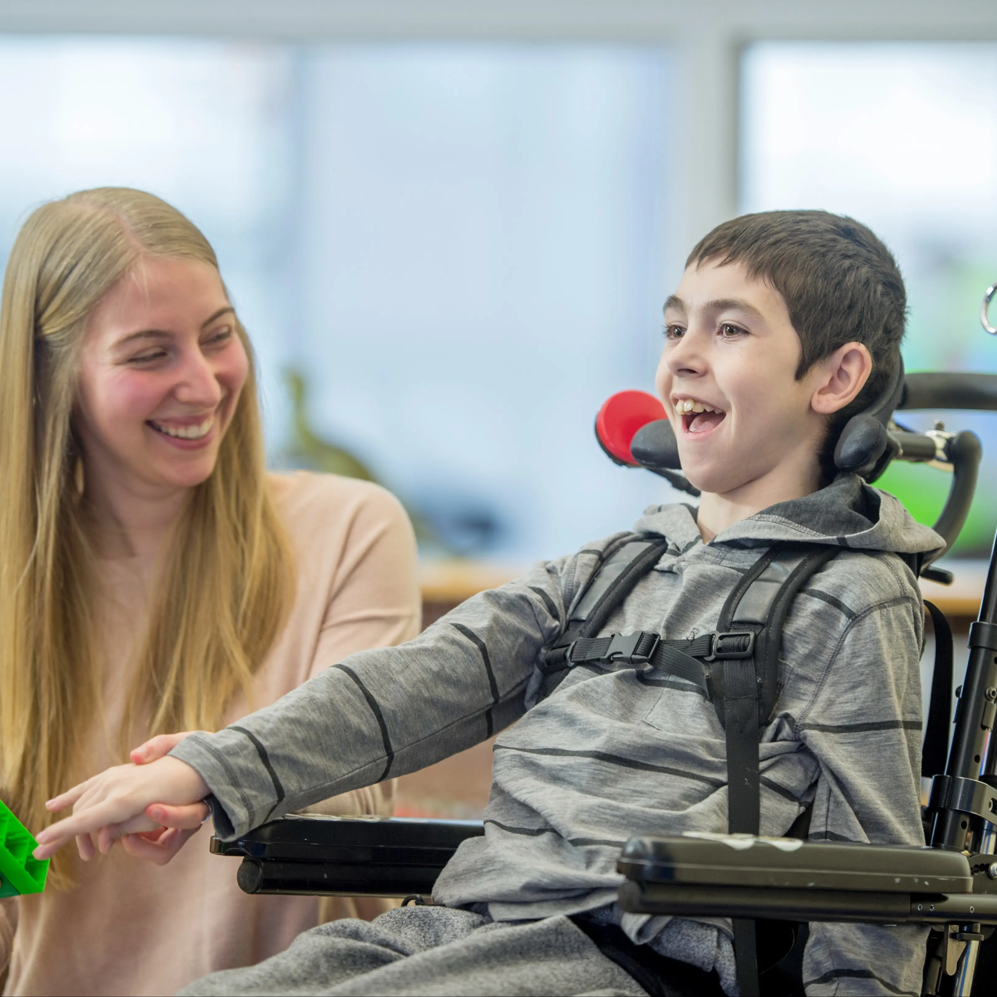 Therapist working with boy in wheelchair.