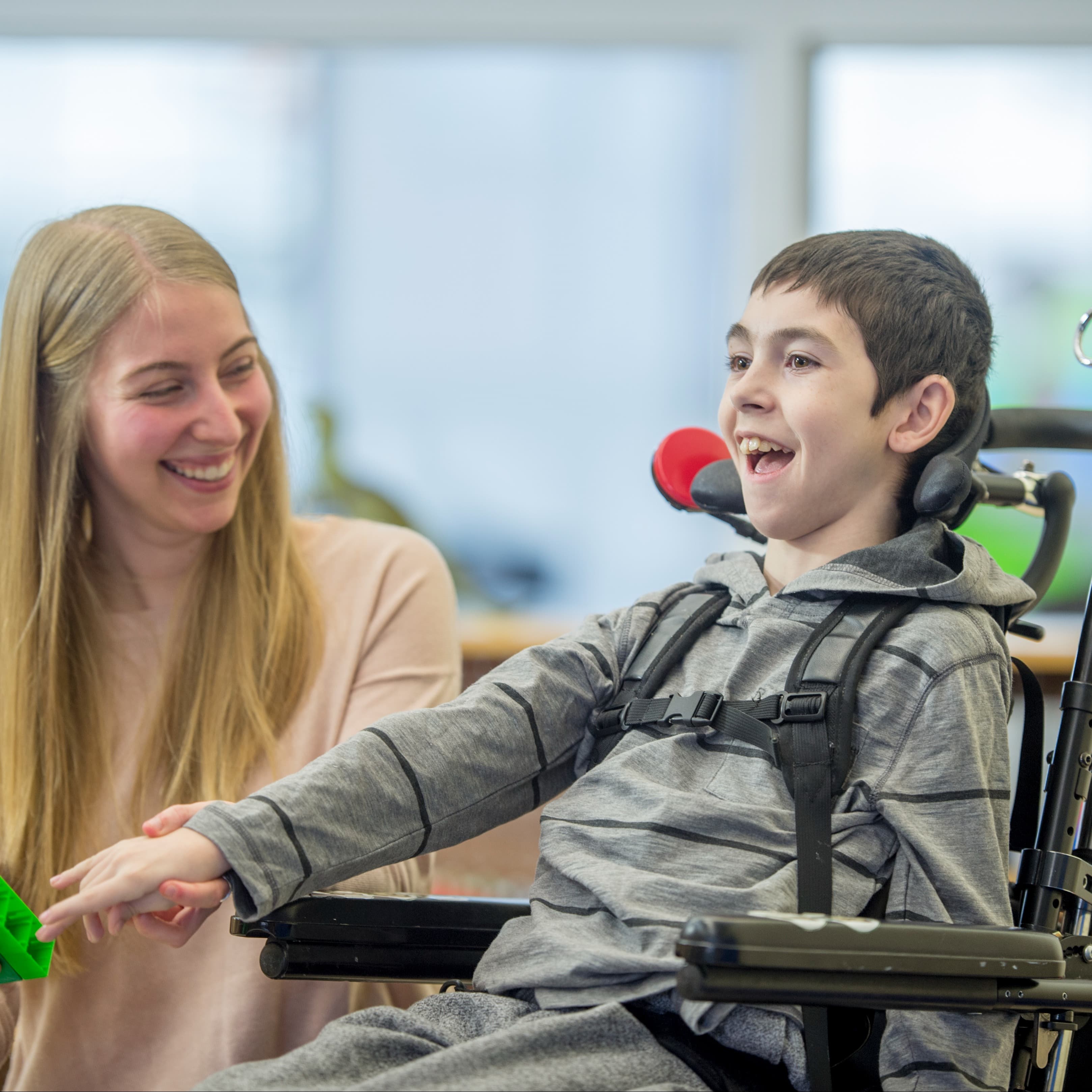 Therapist working with boy in wheelchair.