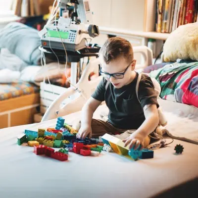 Young boy playing with blocks in his hospital bed at Children's Nebraka.