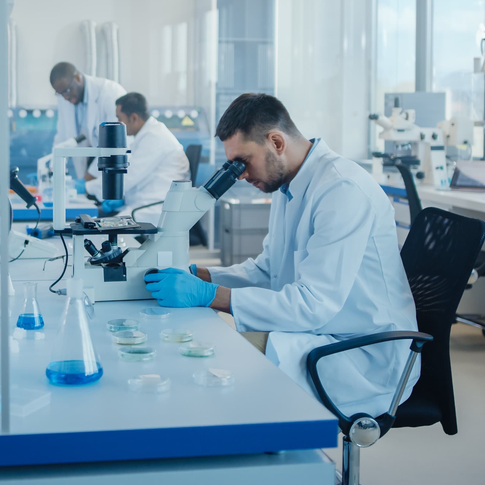 Medical researcher looking through microscope.