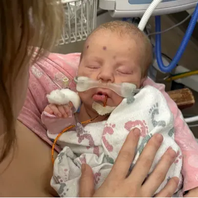 Mother holding young infant Oakley in the hospital.