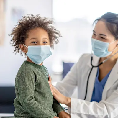 Provider and young patient wearing masks.
