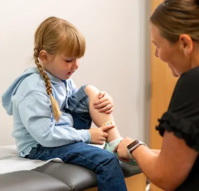 Children's Care Today provider treating young child and giving a band-aid.