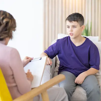 Therapist talking to teenage boy.