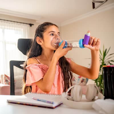 Young girl using an inhaler.