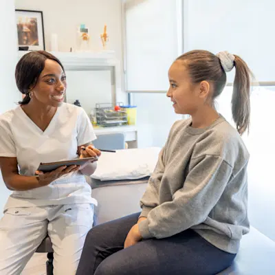 Adolescent girl talking to her doctor.