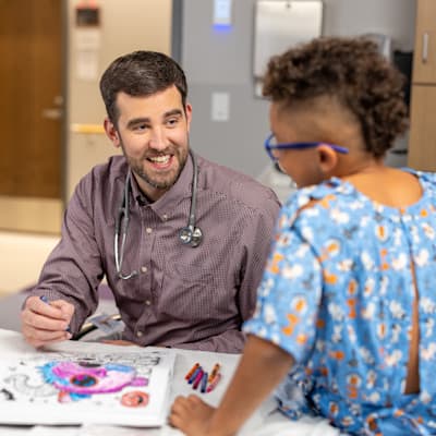 Provider coloring with patient in the hospital.