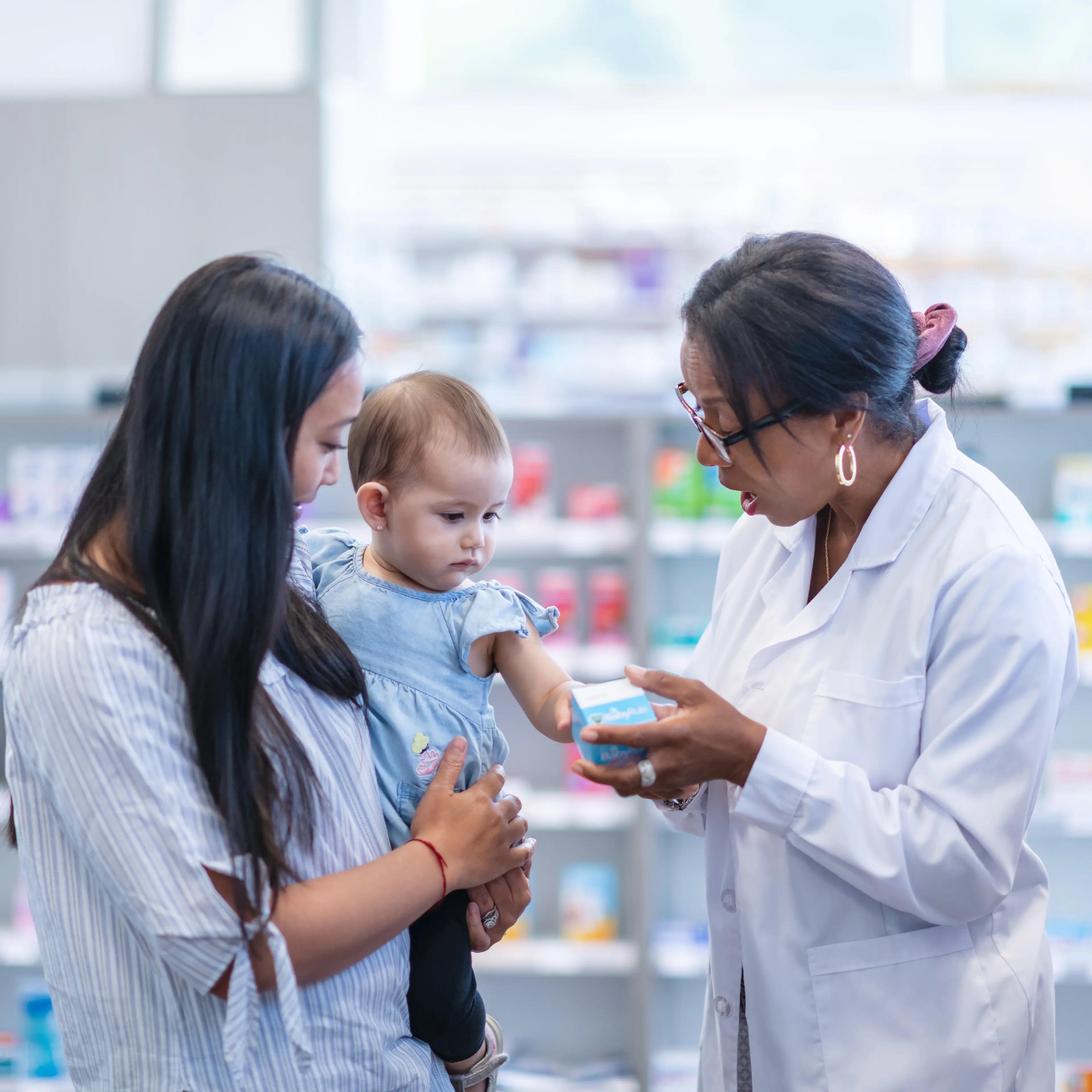 Pharmacist discussing medication with parent.